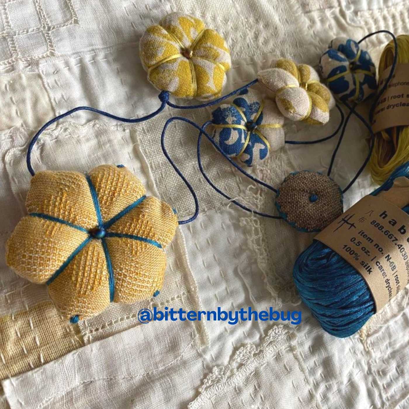 a hand made necklace work-in-progress by @bitternbythebug. Necklace consists of small fabric flowers bound with Habu Textiles Silk Gima tape.
