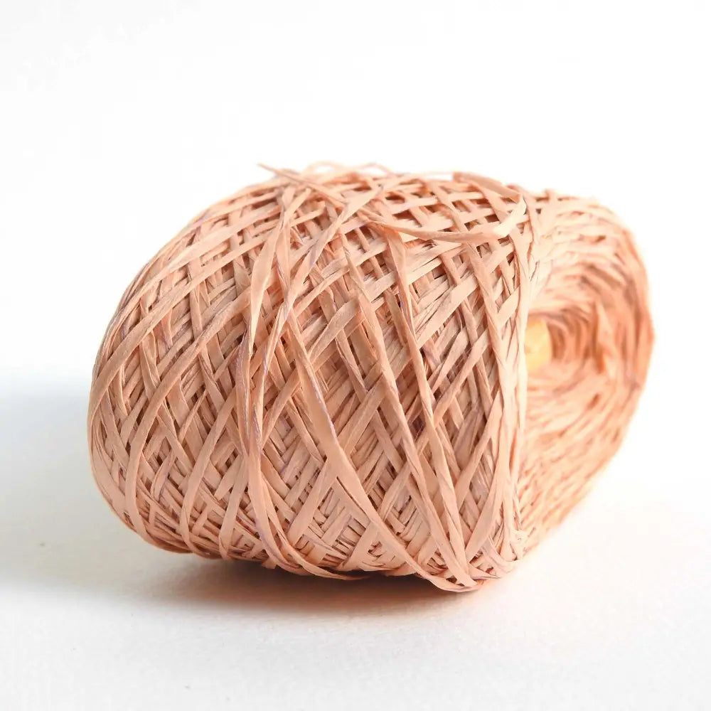 ball of habu textiles raw silk wrapped paper yarn in peach. Japanese paper yarn for weaving, crochet, knitting. Habu Textiles Raw Silk Wrapped Paper Yarn N-24b
