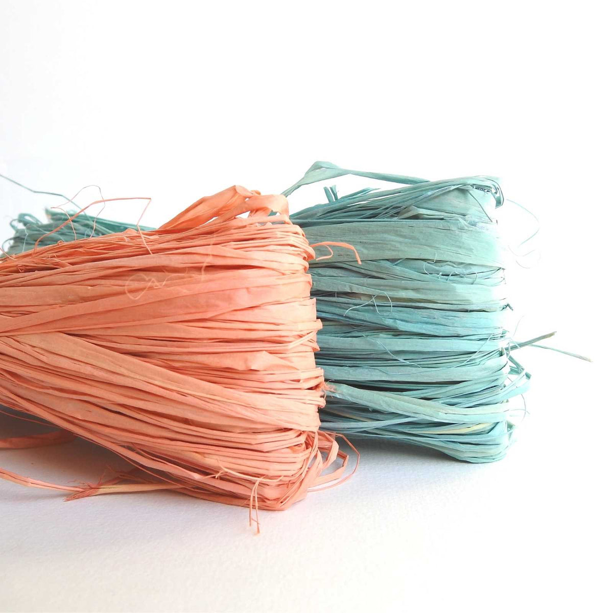 natural raffia yarn for weaving crochet knitting craft floristry gift wrapping. shown here in burnt coral and forget me not. natural sustainable ecofriendly