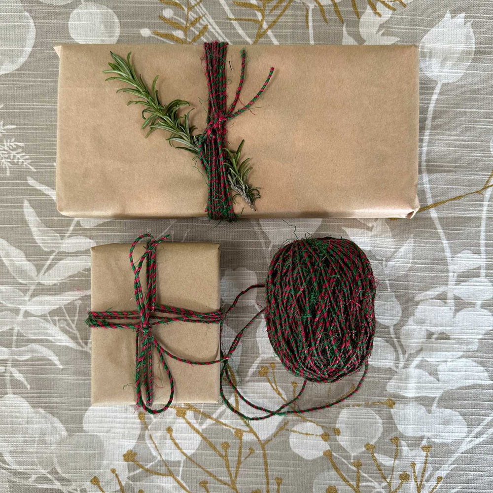 Gift wrapping idea using kraft paper and variegated hemp yarn in red and green. Natural, reusuable and sustainable gift wrapping supplies for christmas, birthday and celebrations