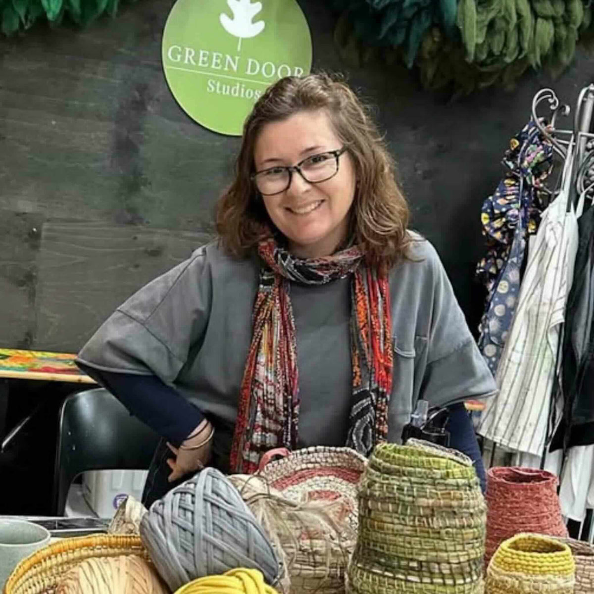 Lou Nade portrait with a selection of weavings using Raffia from Ora Fabulous Fibres