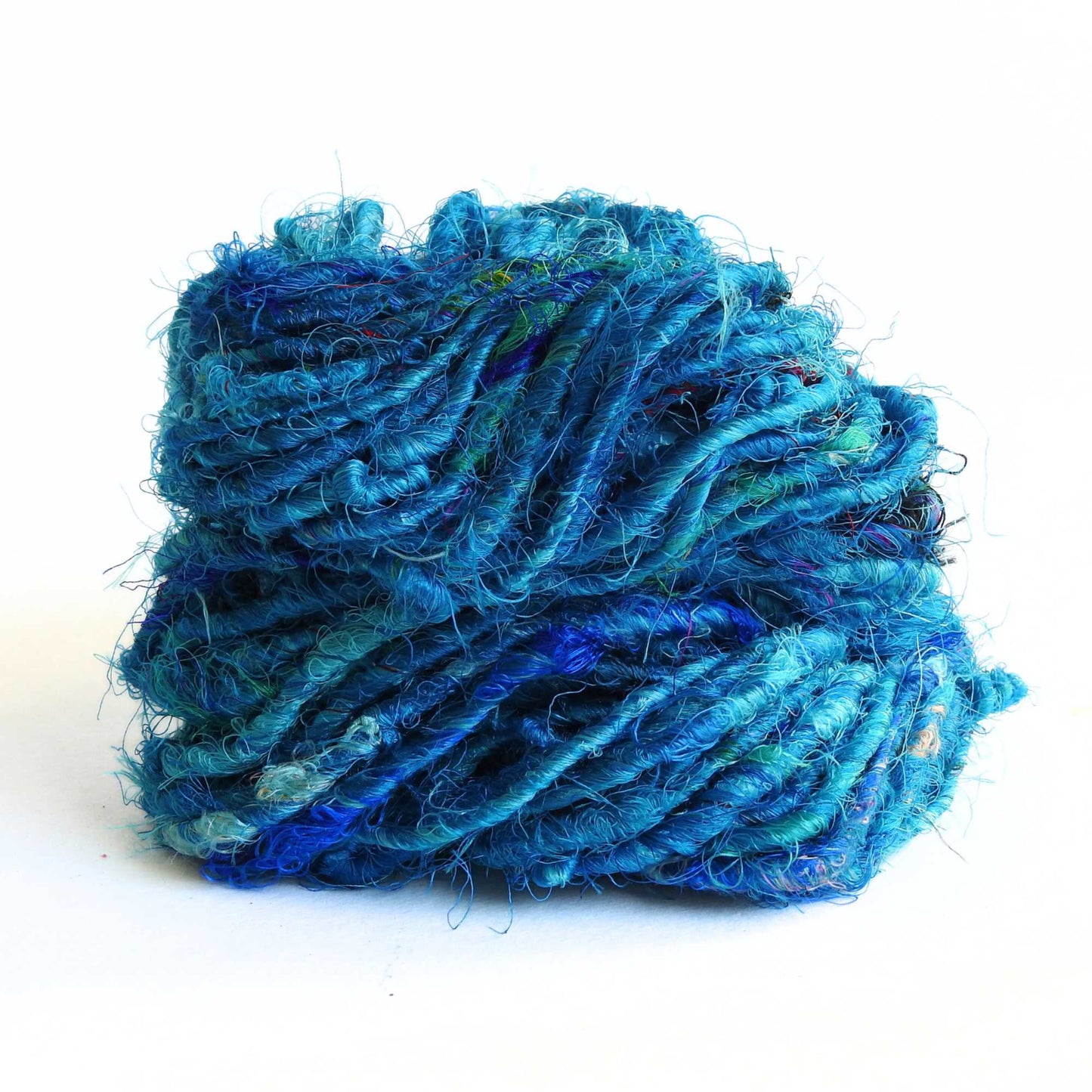 A skein of recycled sari silk yarn in blue. A chunky silky yarn hand crafted from recycled sari silk materials. For use in weaving, crochet, knitting, textile arts.