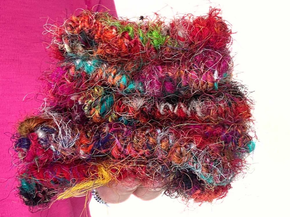 A hand full of Recycled Sari Silk Yarn to demonstrate how much silk waste is recovered.