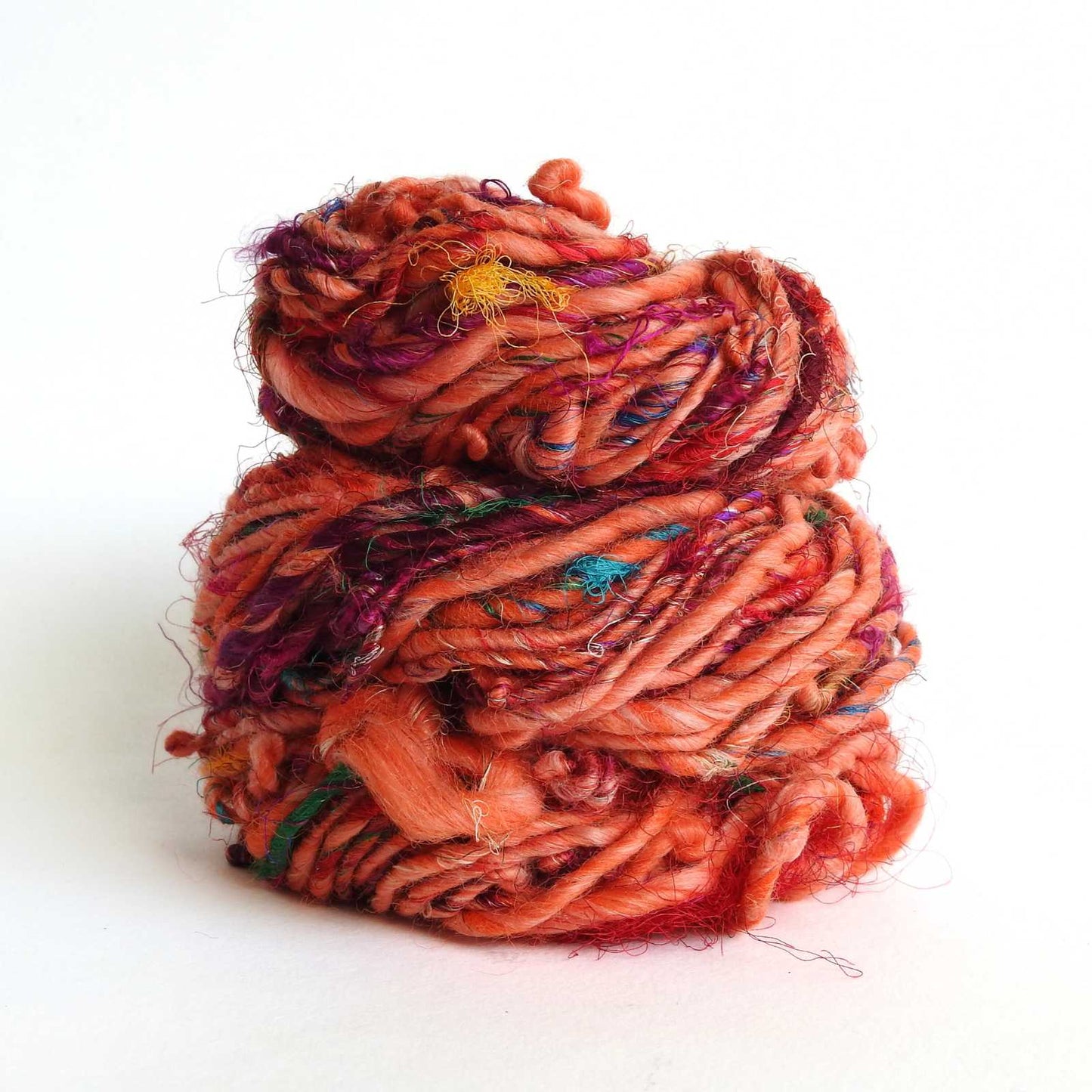 A skein of recycled wool and silk yarn in tigerlily colour. Great texture for knitting, weaving and textile arts.