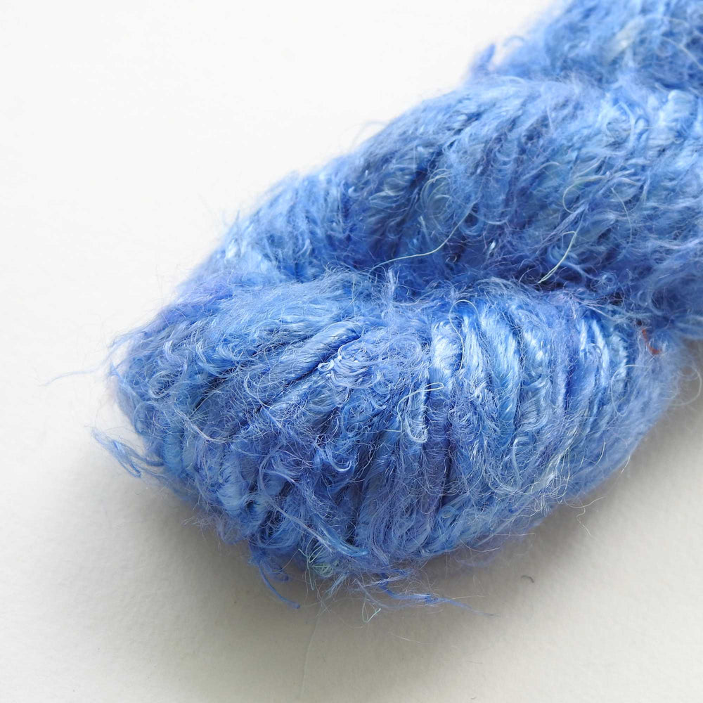 
                  
                    A ball of Banana Silk Yarn in Blue Bell. Natural, vegan banana fiber yarn for weaving, punch needle, knitting, crochet. Soft, squishy, chunky yarn.
                  
                