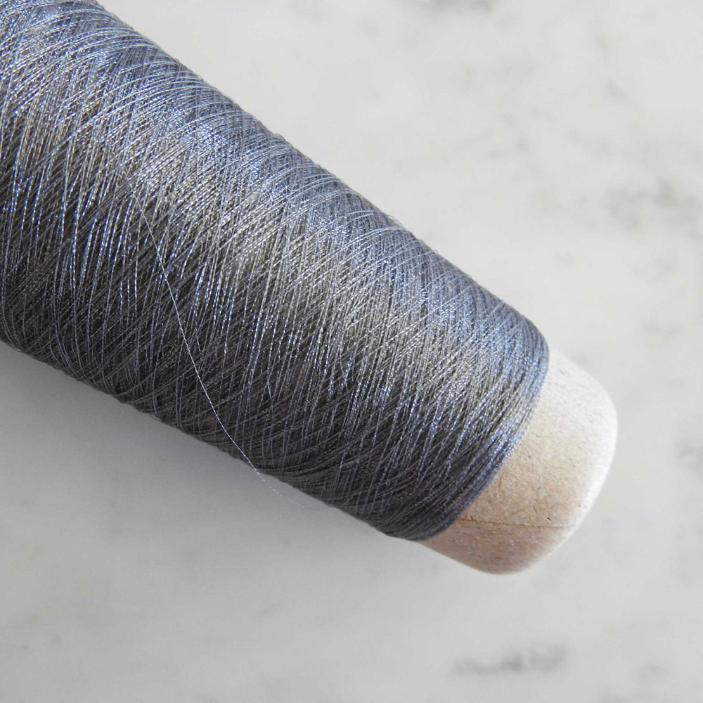 
                  
                    Cone of Raw Silk Stainless Steel yarn in gray. The core of this artisan yarn is stainless steel with fine raw silk wrapped around it. Very strong and can be used alone or with another yarn. Weave, knit or crochet with our Raw Silk Wrapped Stainless Steel yarn. Fine yarn for lace wraps and scarves and beautiful jewelry.Habu Textiles N-88
                  
                
