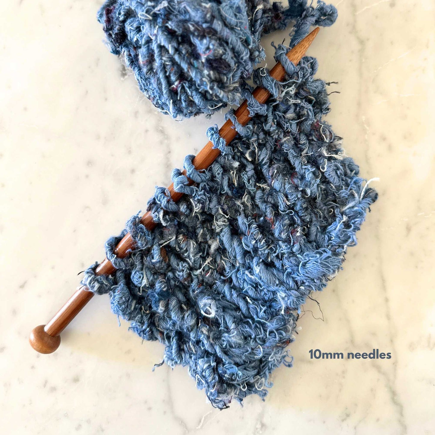 hand knitted sample of Recycled Denim Yarn. A chunky, super thick yarn hand crafted entirely from recycled denim jeans. 100% recycled cotton. Oozes texture.