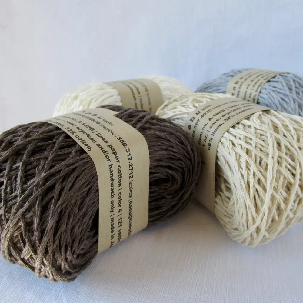 Balls of Habu Linen Cotton Paper Yarn  in Brown, White, Off White and Gray. Use for weaving, knitting and crochet. Create garments, hats, bags, baby clothes. Natural vegan yarn. Use for warp yarn when weaving. Habu yarn A-188