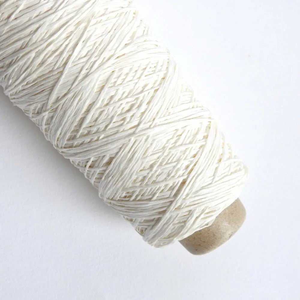 A cone of Habu Textiles Pine Paper yarn. This paper yarn is made from 100% pine and is suitable for knitting, crochet and weaving. Natural colour. Habu Textiles Pine Paper Yarn A-47