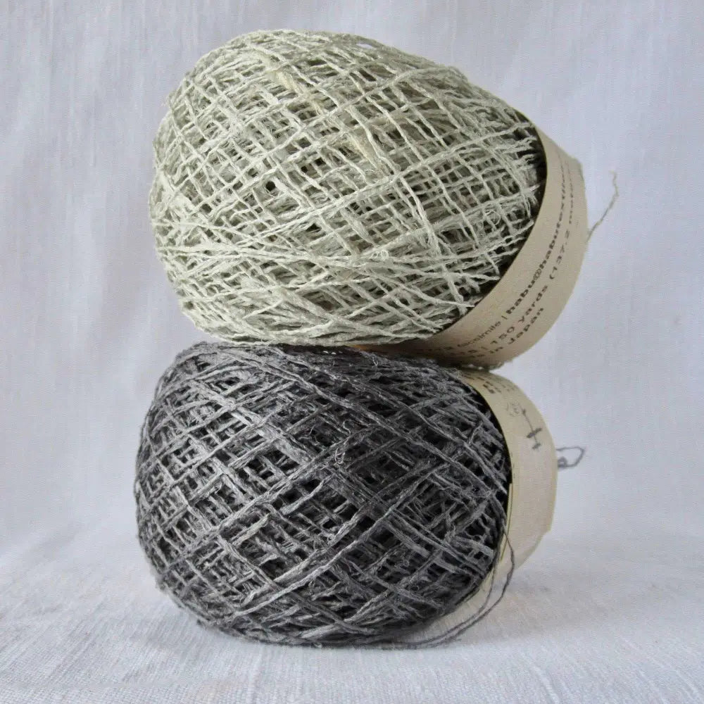 Kibiso Natural Silk Yarn in Light Gray and Charcoal. Japanese Lace yarn in ball for weaving, knitting and crochet. Artisan, specialty yarn with texture to create garments, jewelry, bags, scarves, shawls and wraps with this soft yarn. Knit, crochet and weave. Habu Textiles N-63b