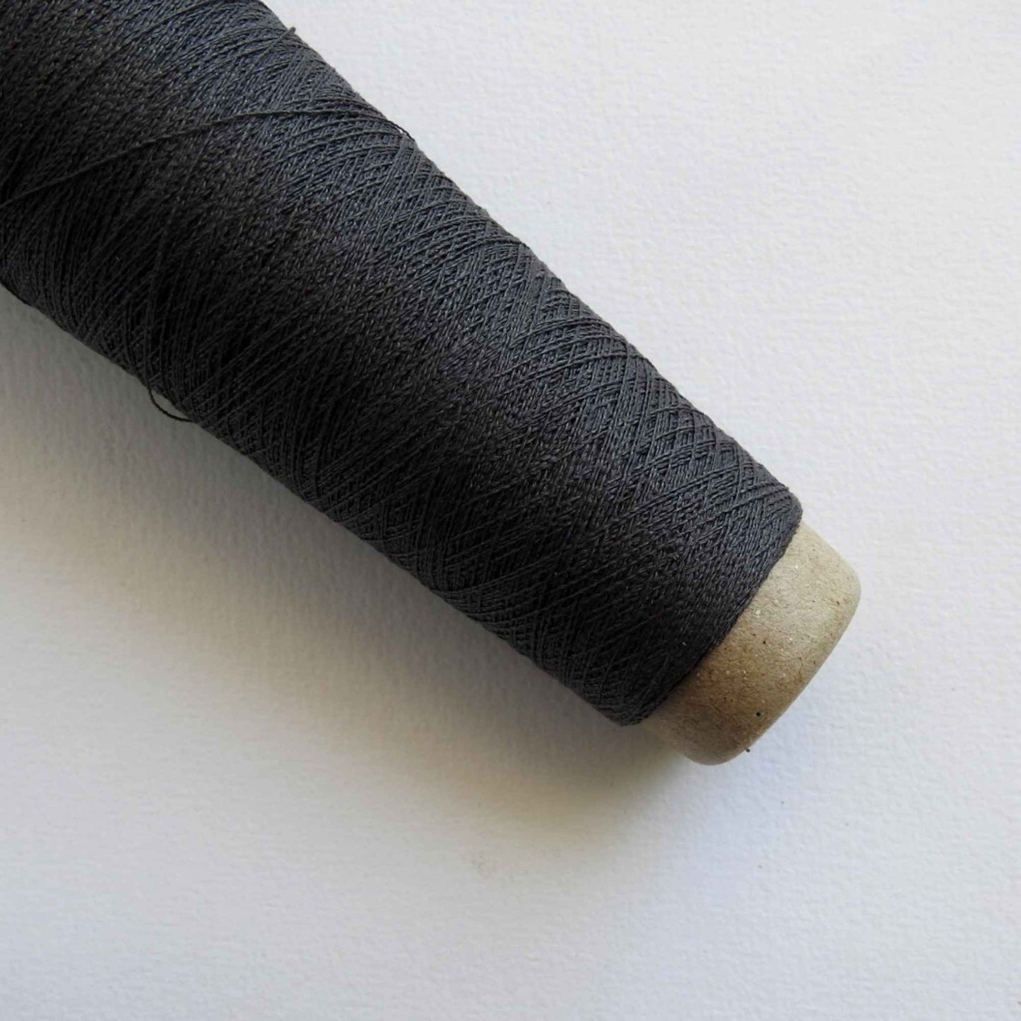 
                  
                    A cone of Silk Stainless Steel lace weight yarn in Charcoal for knitting crochet and weaving. Make beautiful scarves, garments and jewelry. The yarn has a stainless steel core with fine silk wrapped around it. They cone of yarn has a very elegant sheen and is beautiful to look at. Habu Textiles A20
                  
                