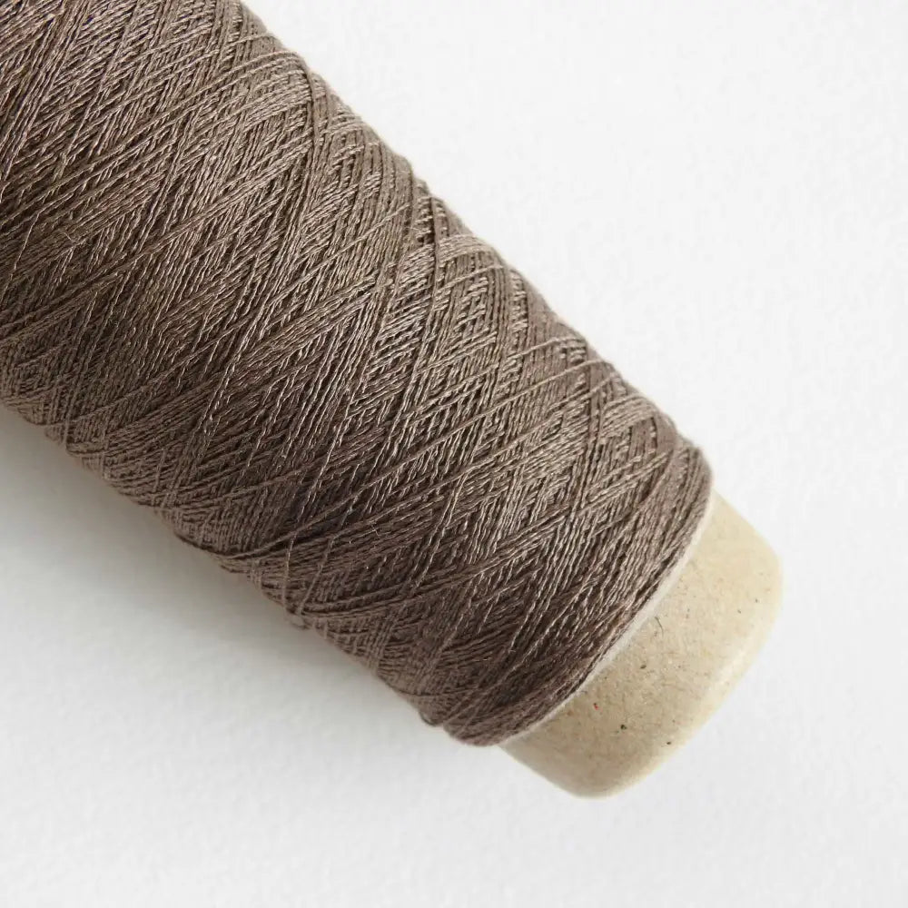 
                  
                    A cone of Silk Stainless Steel lace weight yarn in Brown for knitting crochet and weaving. Make beautiful scarves, garments and jewelry. The yarn has a stainless steel core with fine silk wrapped around it. They cone of yarn has a very elegant sheen and is beautiful to look at. Habu Textiles A20
                  
                