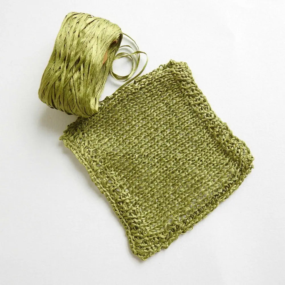 
                  
                    Knitted square of Japanese Silk Tape Yarn in Grass Green. Ball of 100% silk for knitting, crochet, weaving. Make hats, bags, garments, shawls. Silky and luminous fine tape. Habu Textiles N-6B
                  
                