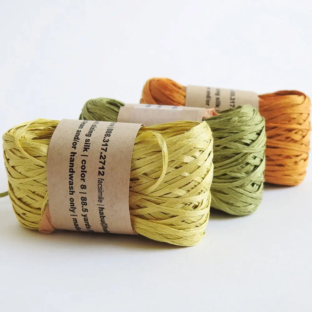 
                  
                    Balls of Habu Silk Tape Yarn in Mustard, Grass and Orange. 100% Japanese silk yarn for knitting, crochet, weaving. Make hats, bags, garments, shawls. Silky and luminous fine tape. Habu Textiles N-6B
                  
                